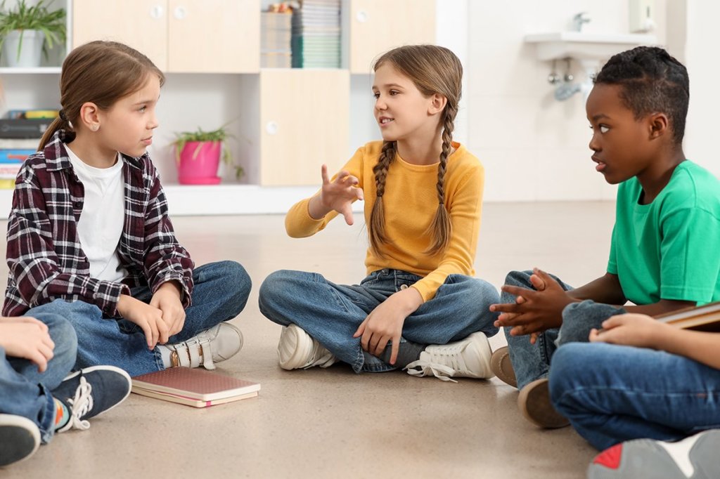 Kinderen praten in een kring in de lagere school.